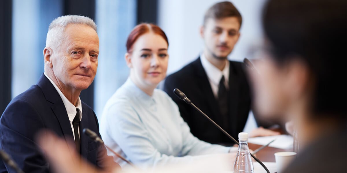 A man and woman in business attire sitting at a conference table