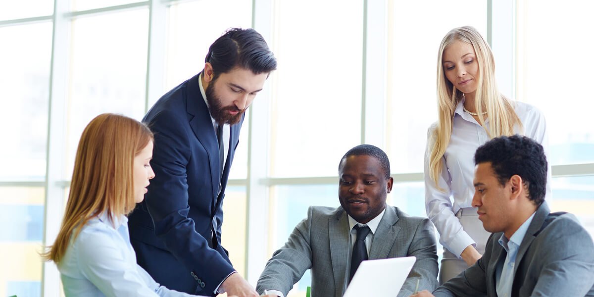 Business team members gathered around a laptop