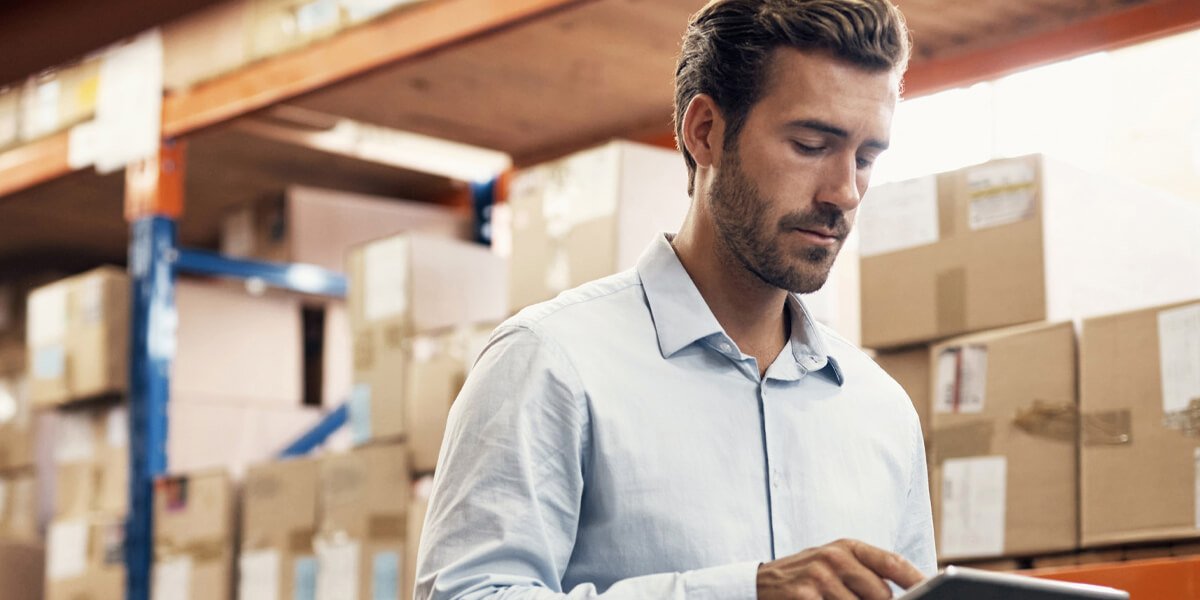 Man in warehouse using tablet for inventory control