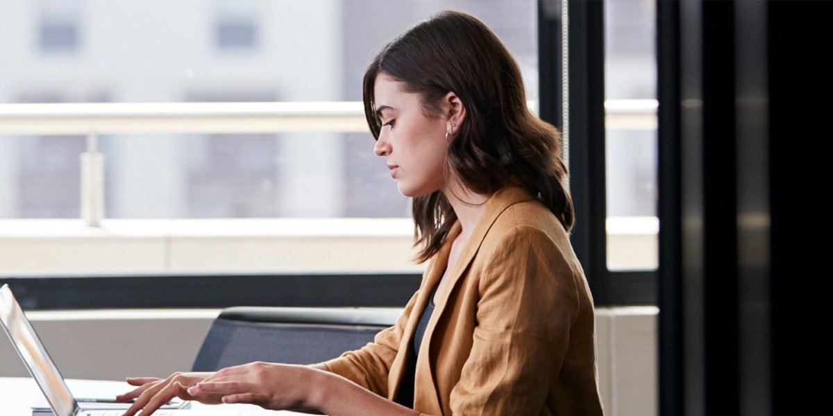 A woman sitting at a desk with a laptop