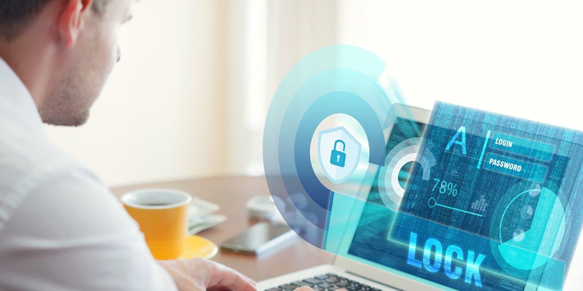 An individual using a laptop featuring a security icon on the screen