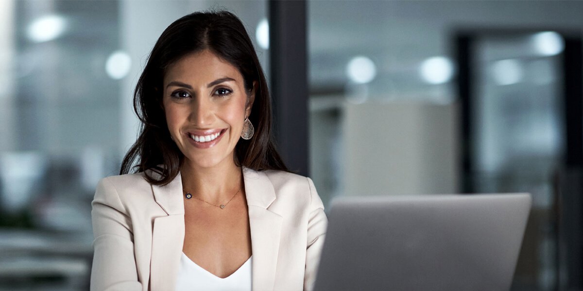 Female smiling and using a laptop