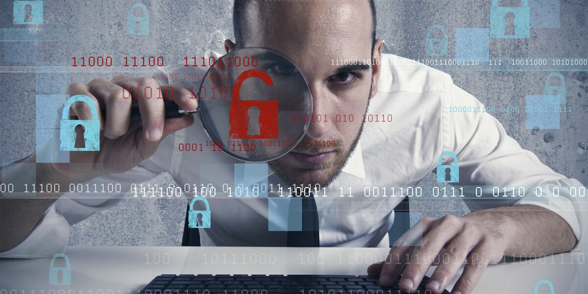 Man examining computer screen with magnifying glass